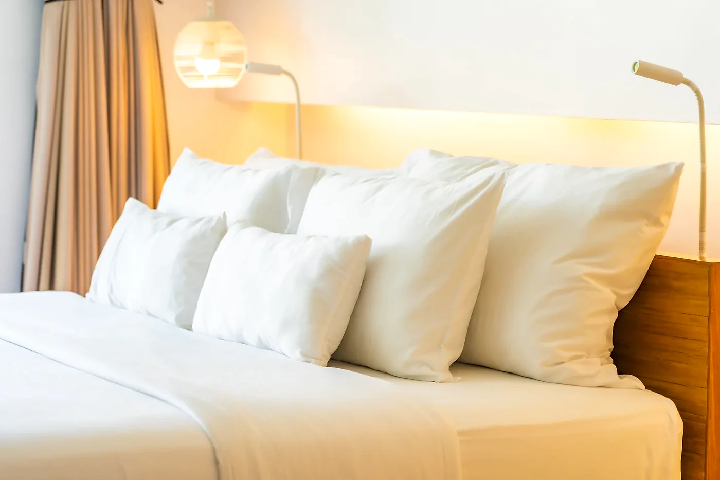 Cama arrumada com roupa de cama branca
